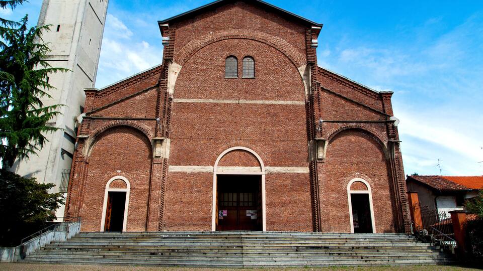 A large brick church with a clock tower and arched windows.