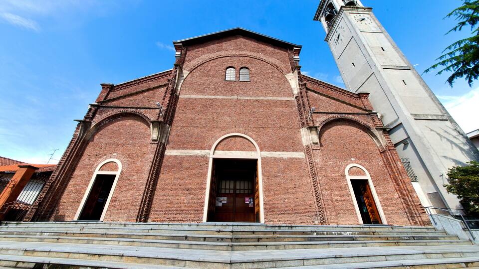 A red brick church with a clock tower and arched windows.