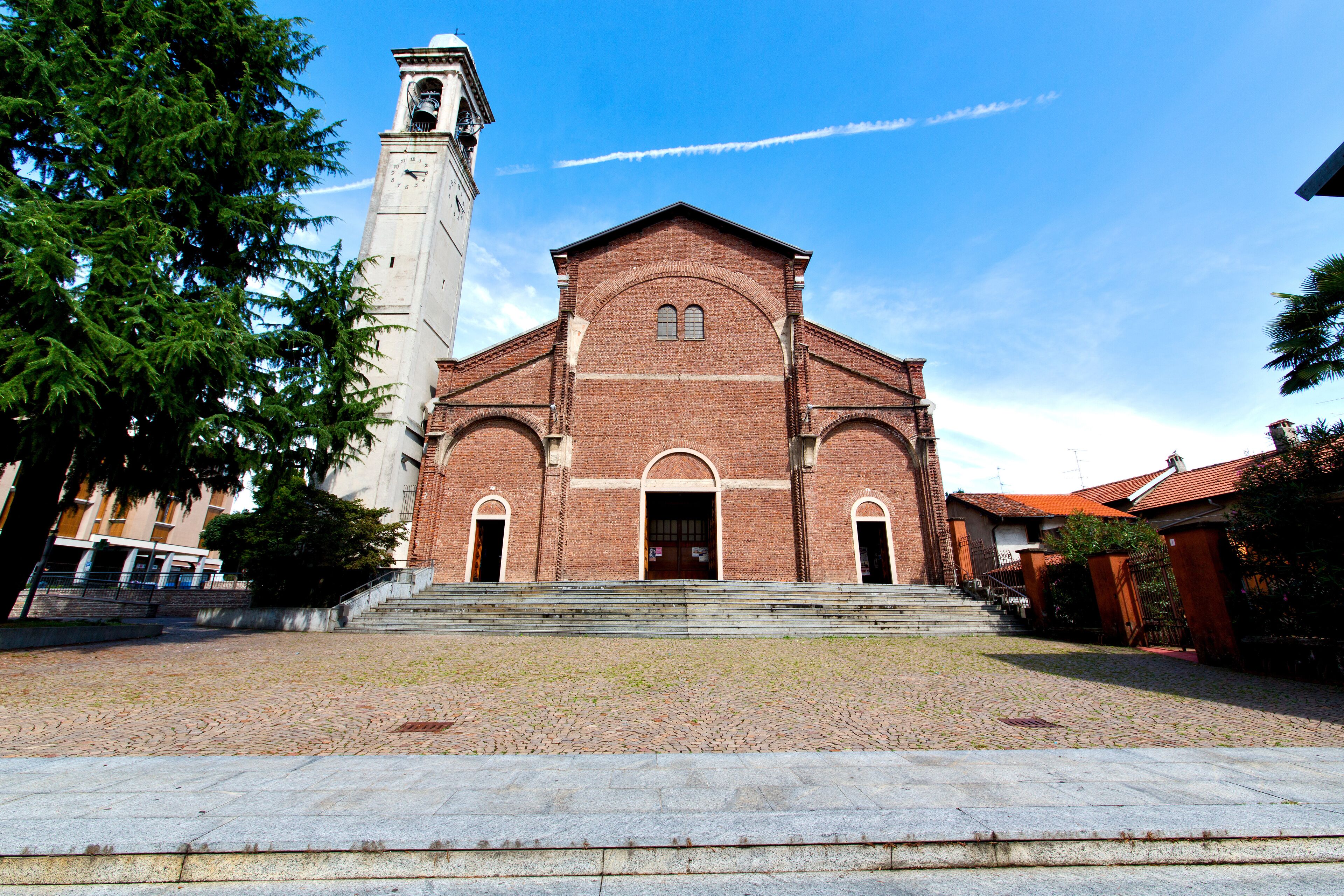 A historic church with a bell tower and a cobblestone courtyard.