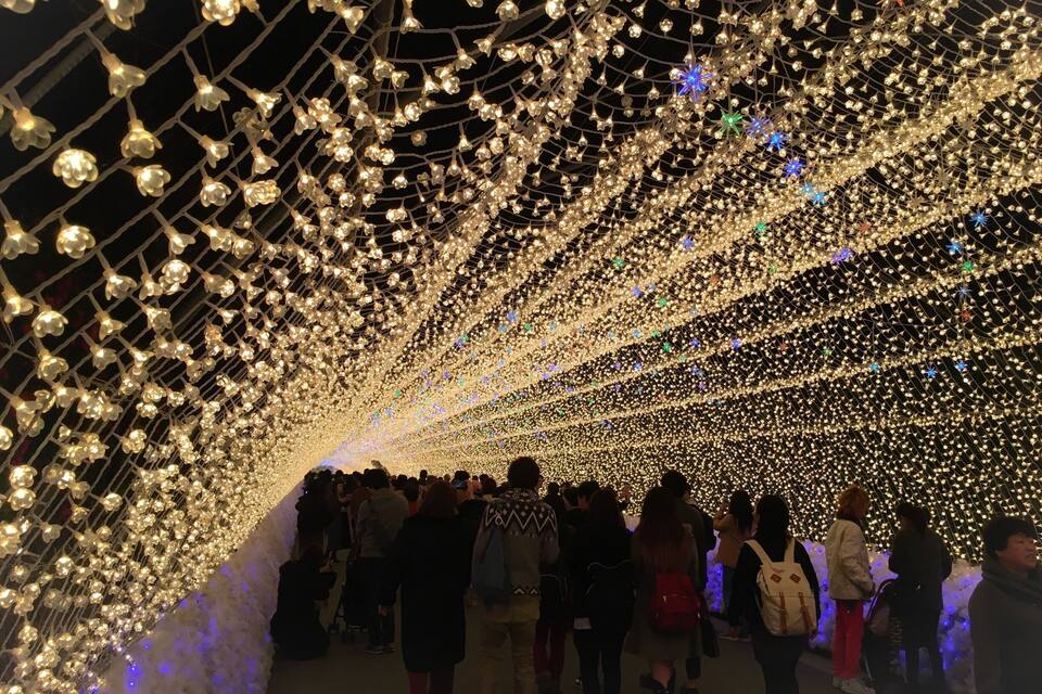 A tunnel of lights with people walking through.