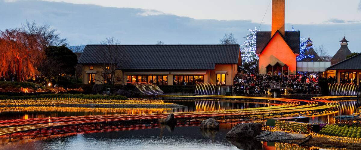 A riverside view with illuminated pathways, a church, and a traditional building.