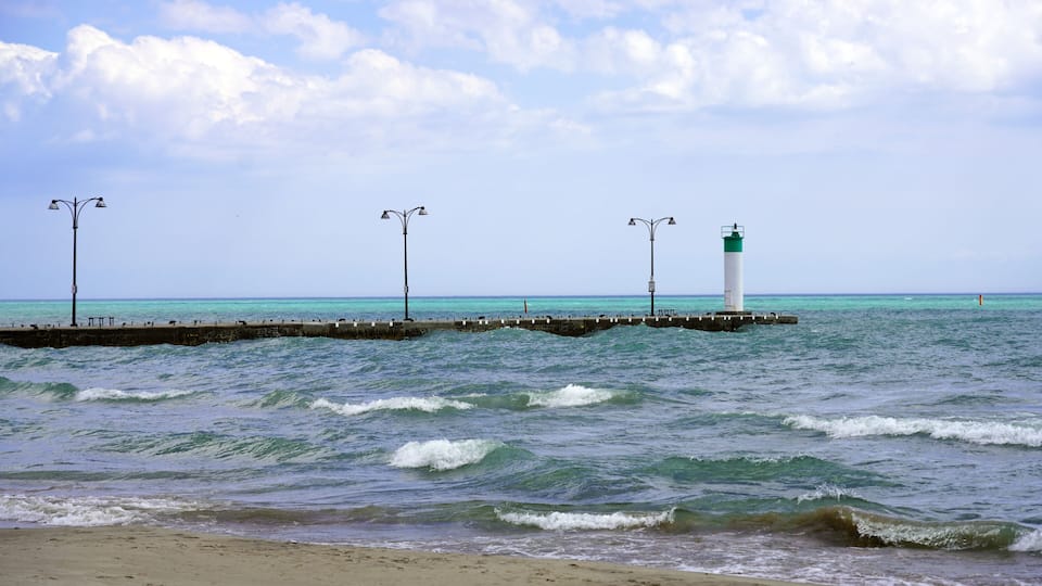 A lighthouse, a pier, and the ocean.