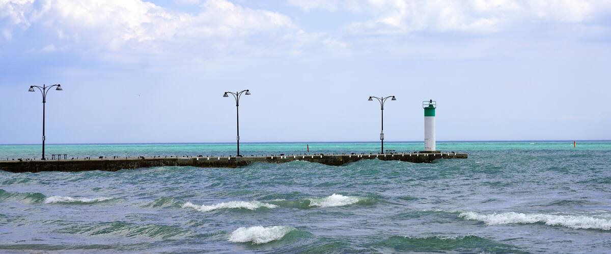 A lighthouse, a pier, and the ocean.