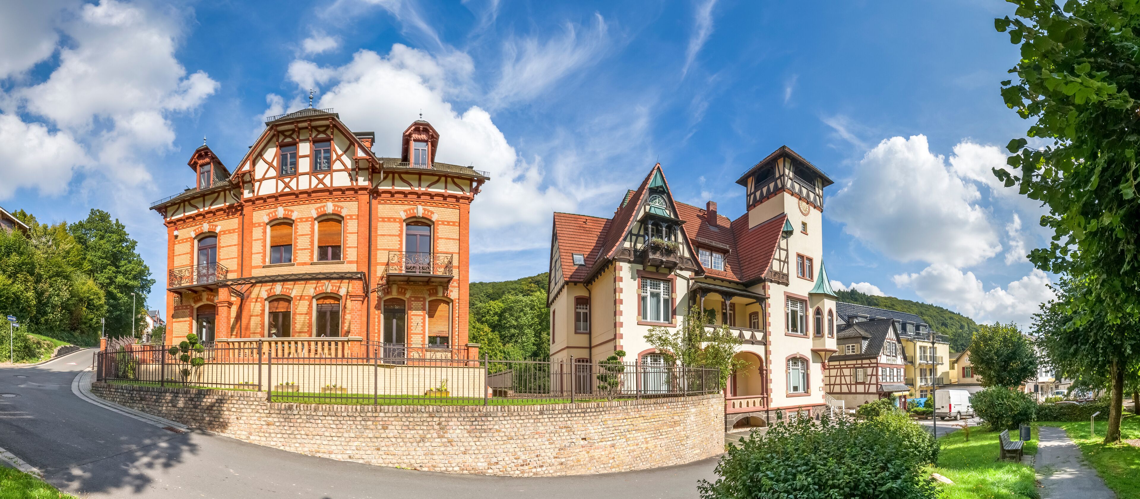 A historic building with a clock tower, surrounded by lush greenery and a clear blue sky.