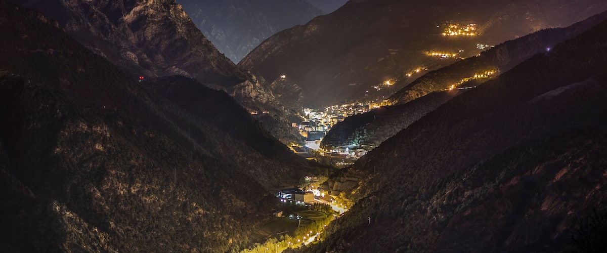 A valley at night with a town illuminated by streetlights.