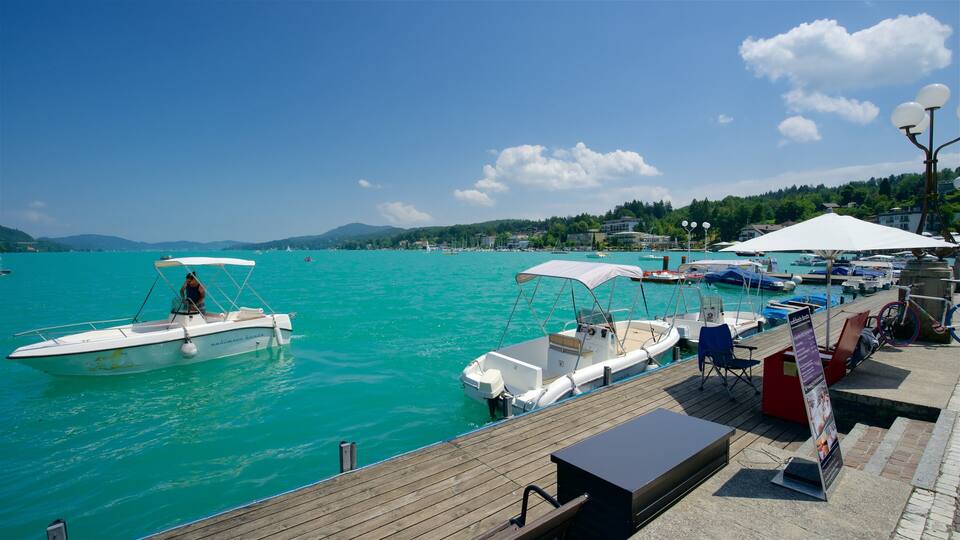 A marina with boats docked, a wooden deck, and a clear blue sky.