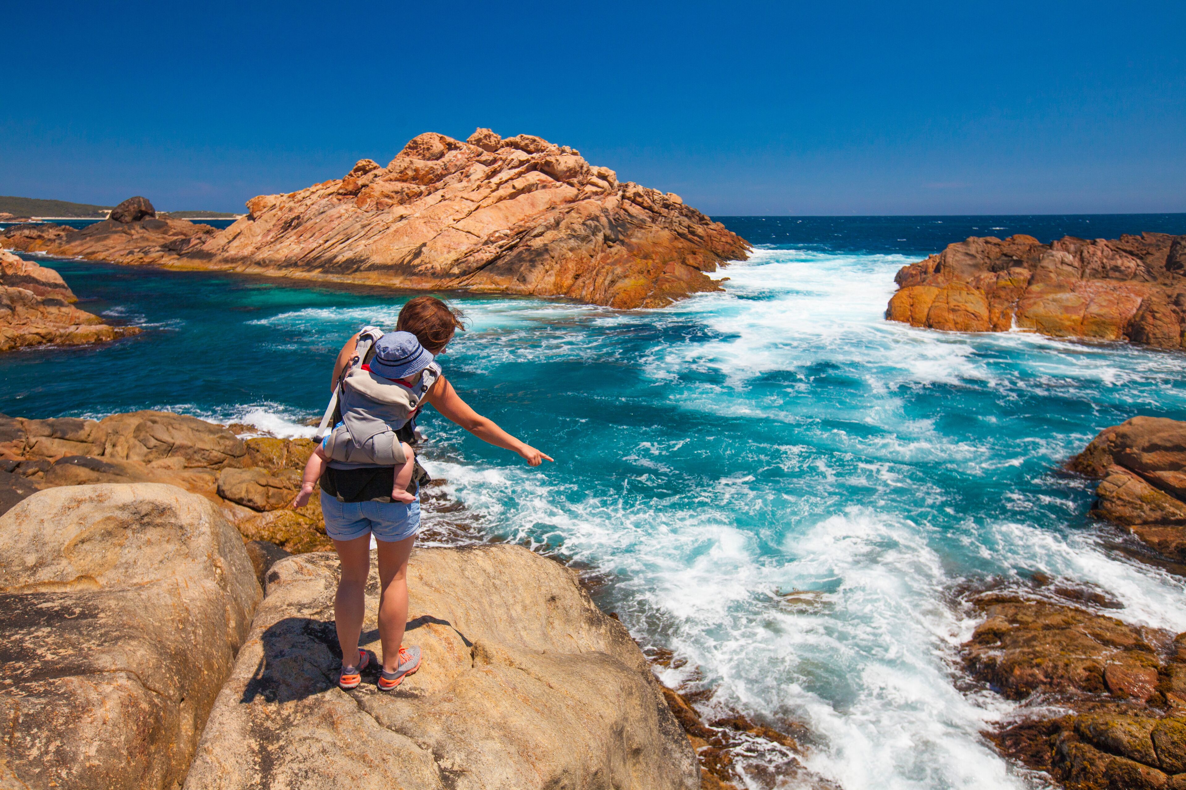 Mother with baby on beach at Canal Rocks, Cape Naturaliste, Australia