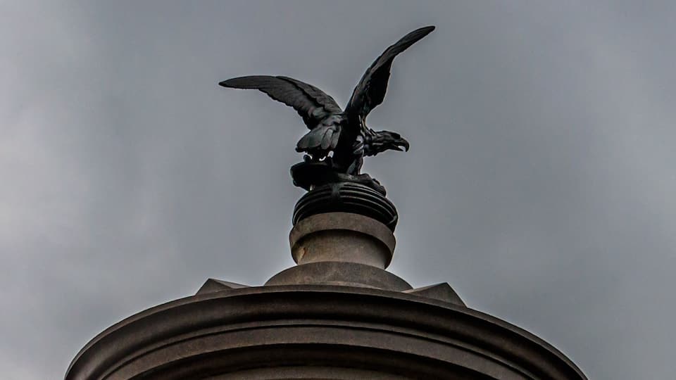 A monument with an eagle statue and text reading "Sickles' Excellence."