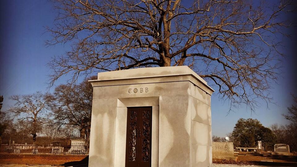 A monument with a tree in front of it.