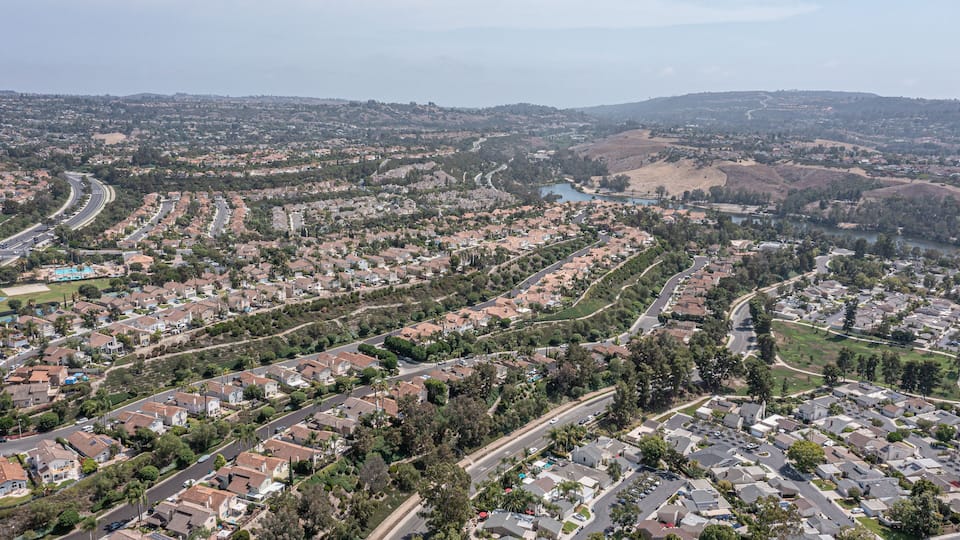 A residential area with winding roads, houses, and a river.