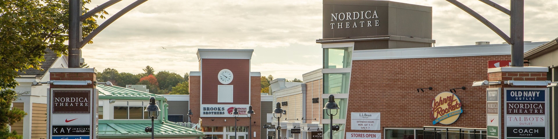 La entrada a la estación Freeport Village con carteles de Nordica Theatre, Brooks Brothers y otros comercios locales.