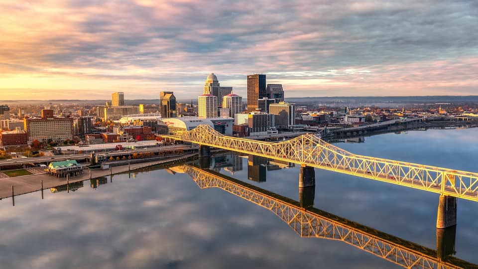 Aerial shot of the skyline of Louisville and the bridge at sunrise.