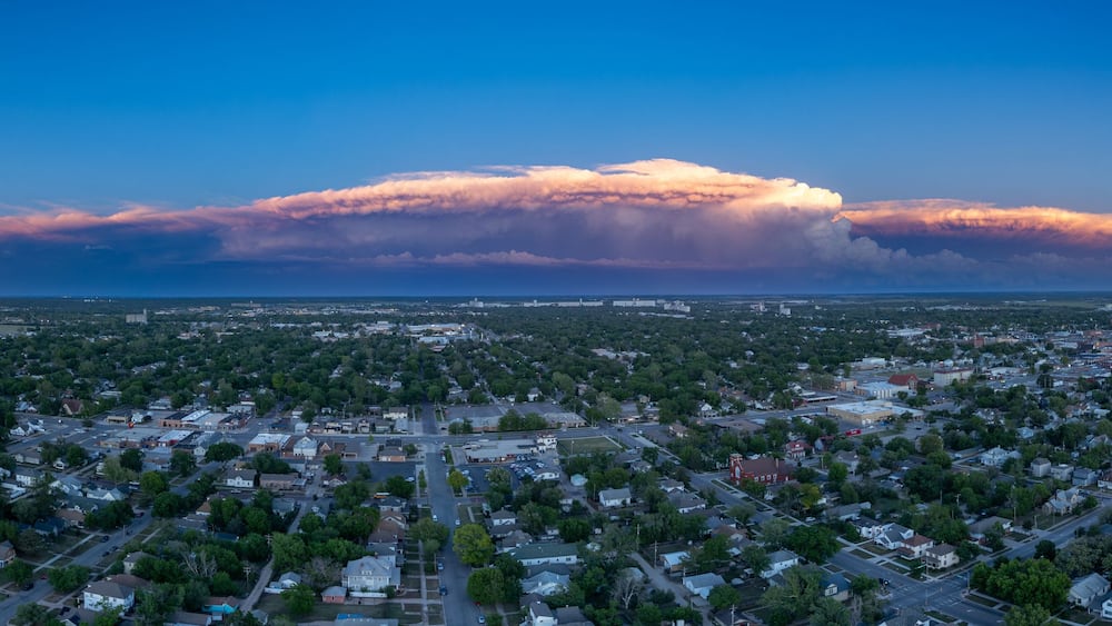 A cityscape with a large cloud formation in the sky.