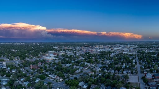 A cityscape with a large cloud formation in the sky.