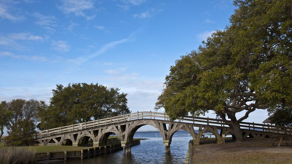 A stone bridge over water with trees on either side.