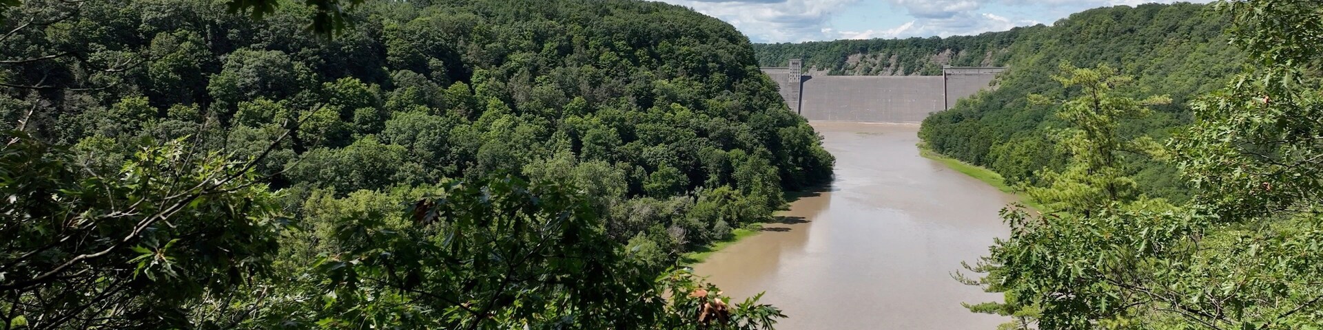 Mt Morris Dam in New York State on Genesse River at Letchworth State Park with blue sky and clouds in a beautiful countryside landscape with green trees in summer season