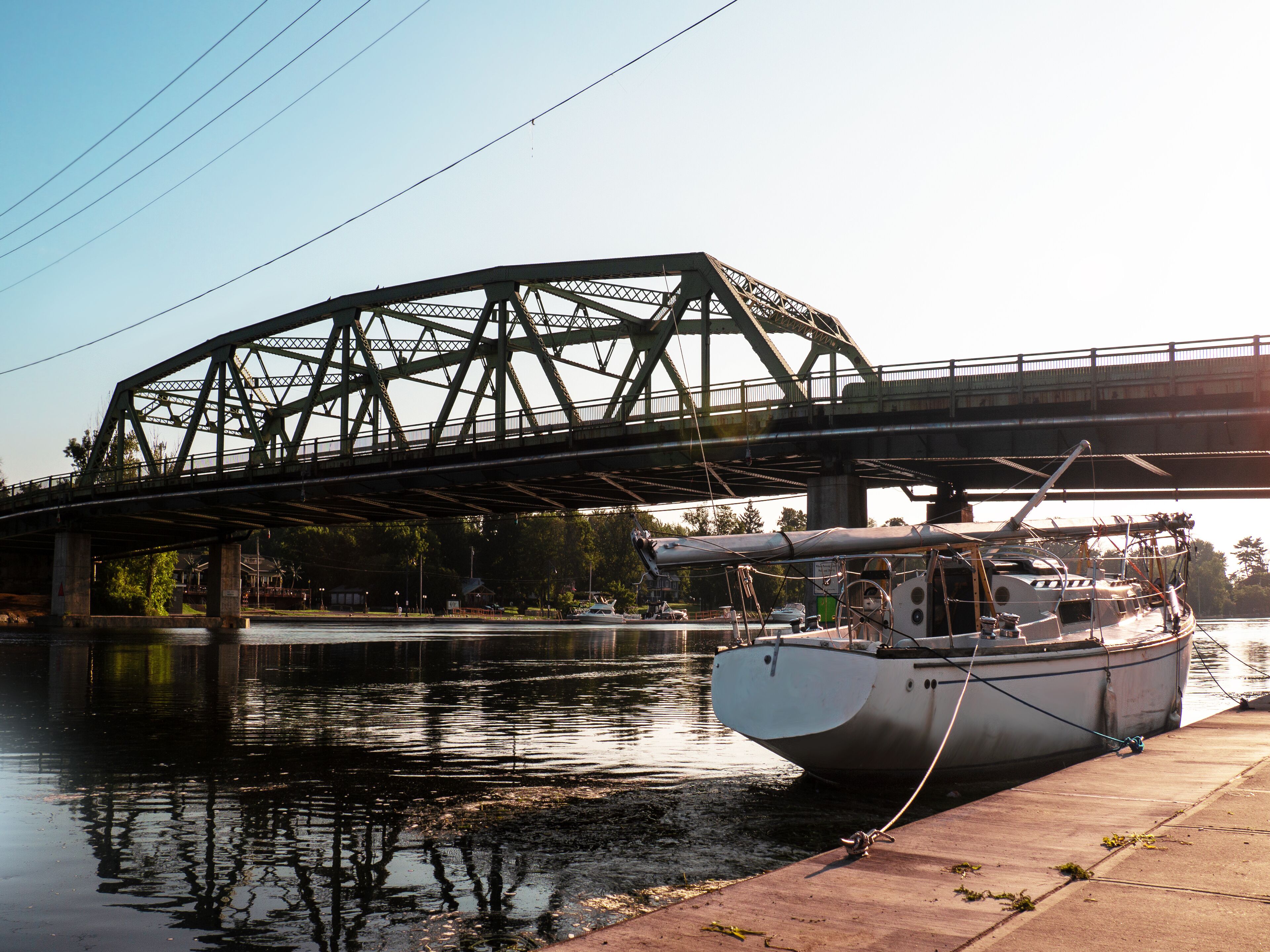 A bridge over a river with a boat docked on the right.