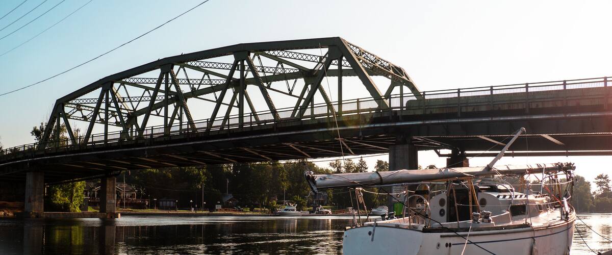 A bridge over a river with a boat docked on the right.