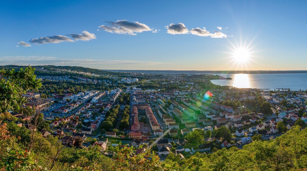 Panorama Sunset view from above of Huskvarna Skyline with reflecting sun on big Lake Vattern near Jonkoping, Smaland, Sweden.