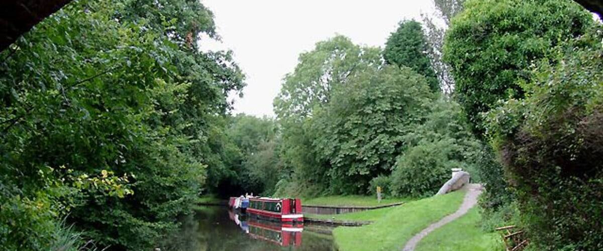 Stratford-upon-Avon Canal at Hockley Heath, Solihull. The canal is seen here from below the arch of Bridge No 25, which carries the A4300 Stratford Road from Solihull. Ahead to the right is a short canal arm which used to lead to a coal wharf. 1716384 The Stratford-upon-Avon Canal was built from King's Norton Junction (with the Worcester and Birmingham Canal) to Kingswood Junction (with the Warwick and Birmingham Canal - now Grand Union Canal) by 1803. A second phase of construction started in 1812, and by 1815 was connected to the River Avon in Stratford. Total length 25.5 miles, with 54 locks.