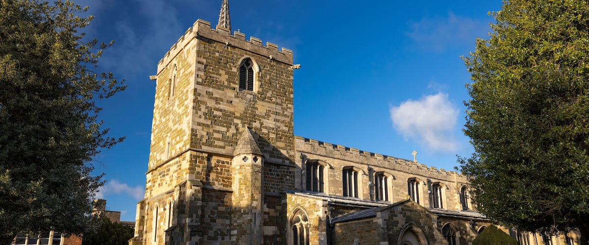 A historic stone church with a tall bell tower and arched windows.