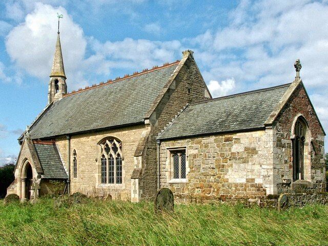 A stone church with a steeple and arched windows.