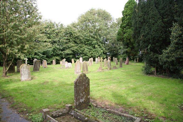 A cemetery with numerous headstones and trees.