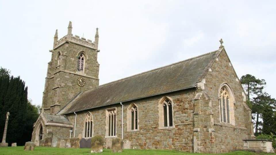 A historic stone church with a bell tower and arched windows.