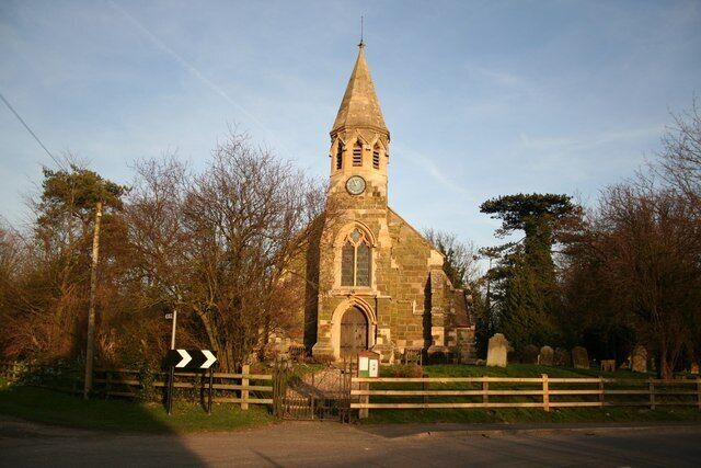 A church with a tall steeple and a clock.