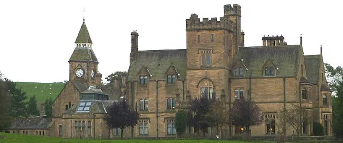 A large, historic building with a clock tower and a prominent tower.
