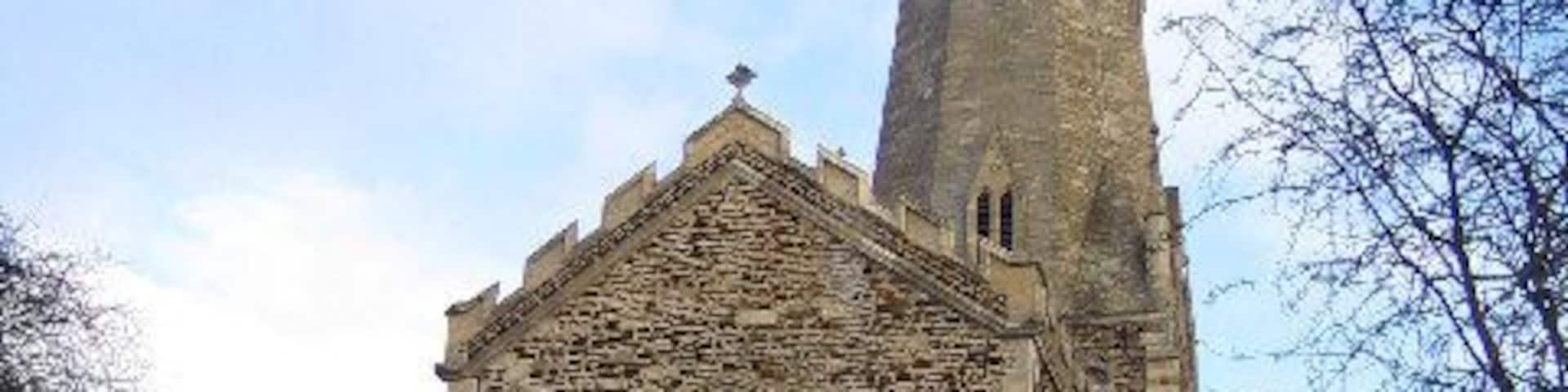 Leighton Buzzard: All Saints Church. A church has stood on the site of the present building in Leighton Buzzard for more than 1,000 years. Today's church dates from 1277 and has a 60 metre high broach spire on a squat tower, which is a prominent landmark in the locality. Inside it boasts a magnificent 15th Century roof adorned with angels and saints contrasting with 25 ferocious gargoyles around the outside. The Church was severely damaged by fire in 1985. The fire happened just as a restoration programme was nearing completion. It destroyed most of the nave and chancel roofs and caused serious structural damage to the tower, spire, and the vestry areas and a number of the windows were damaged beyond repair. The ring of ten bells was lost as were both the organs. The total cost of the damage exceeded £1.5 million pounds. http://www.allsaintslb.org.uk/ for the Church's website.
