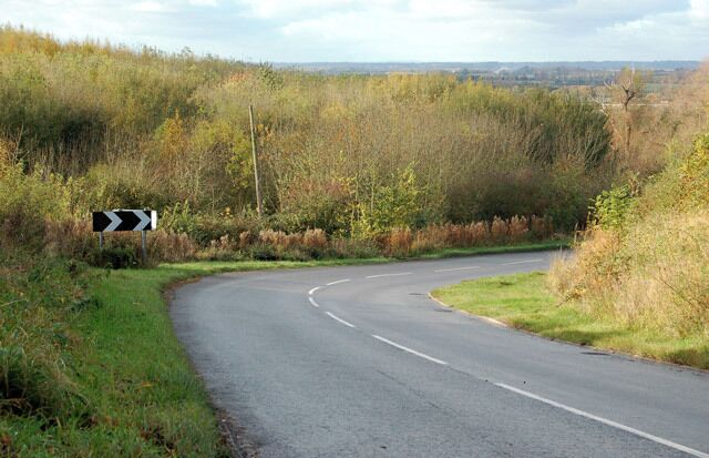 A curving road with a chevron sign indicating a sharp bend to the right.