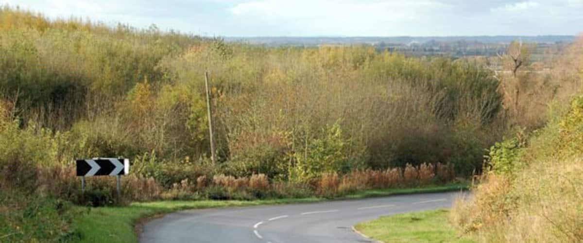 A curving road with a chevron sign indicating a sharp bend to the right.