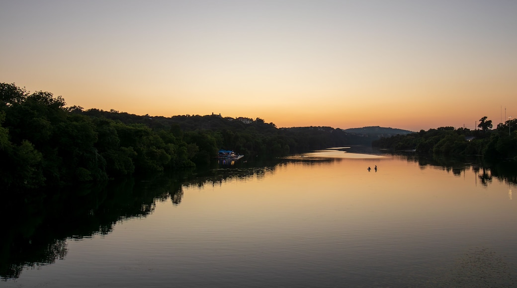 As the day gracefully transitions to dusk, Lady Bird Lake in Austin, Texas, becomes a canvas for nature's beauty. The serene river mirrors the warm tones of the setting sun.