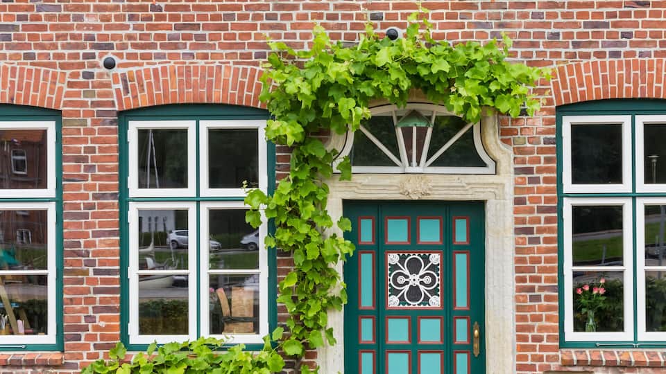 A brick building with a green door and windows.
