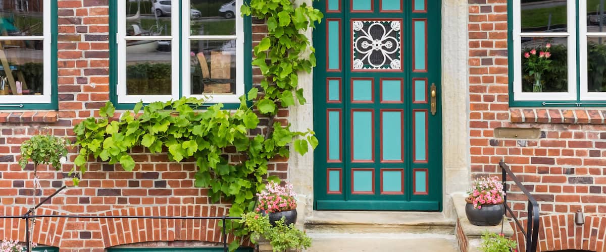 A brick building with a green door and windows.