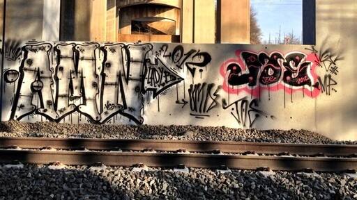 The underside of the tracks. The R7 barrels by beneath while freight trains truck above.