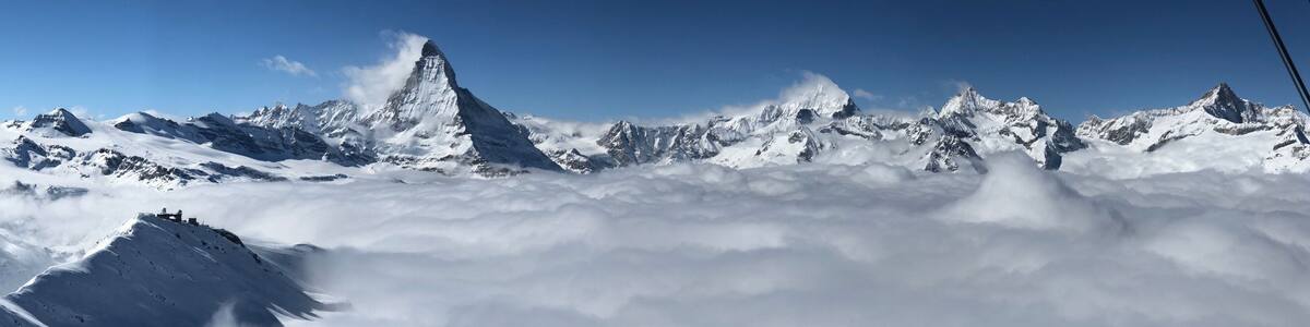 A snow-covered mountain peak with a clear sky above.