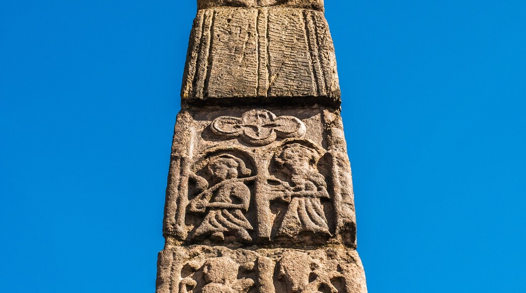 A tall stone column with intricate carvings and a flat top.