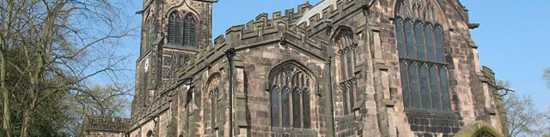 A historic church with a tall tower and large arched windows.