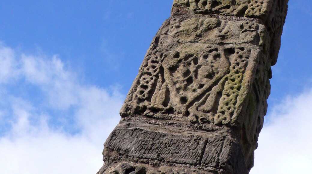 A tall, intricately carved stone monument against a clear blue sky.