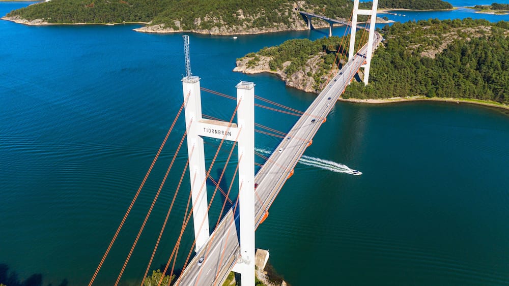 Un pont enjambant une étendue d’eau importante, avec une île boisée en arrière-plan.