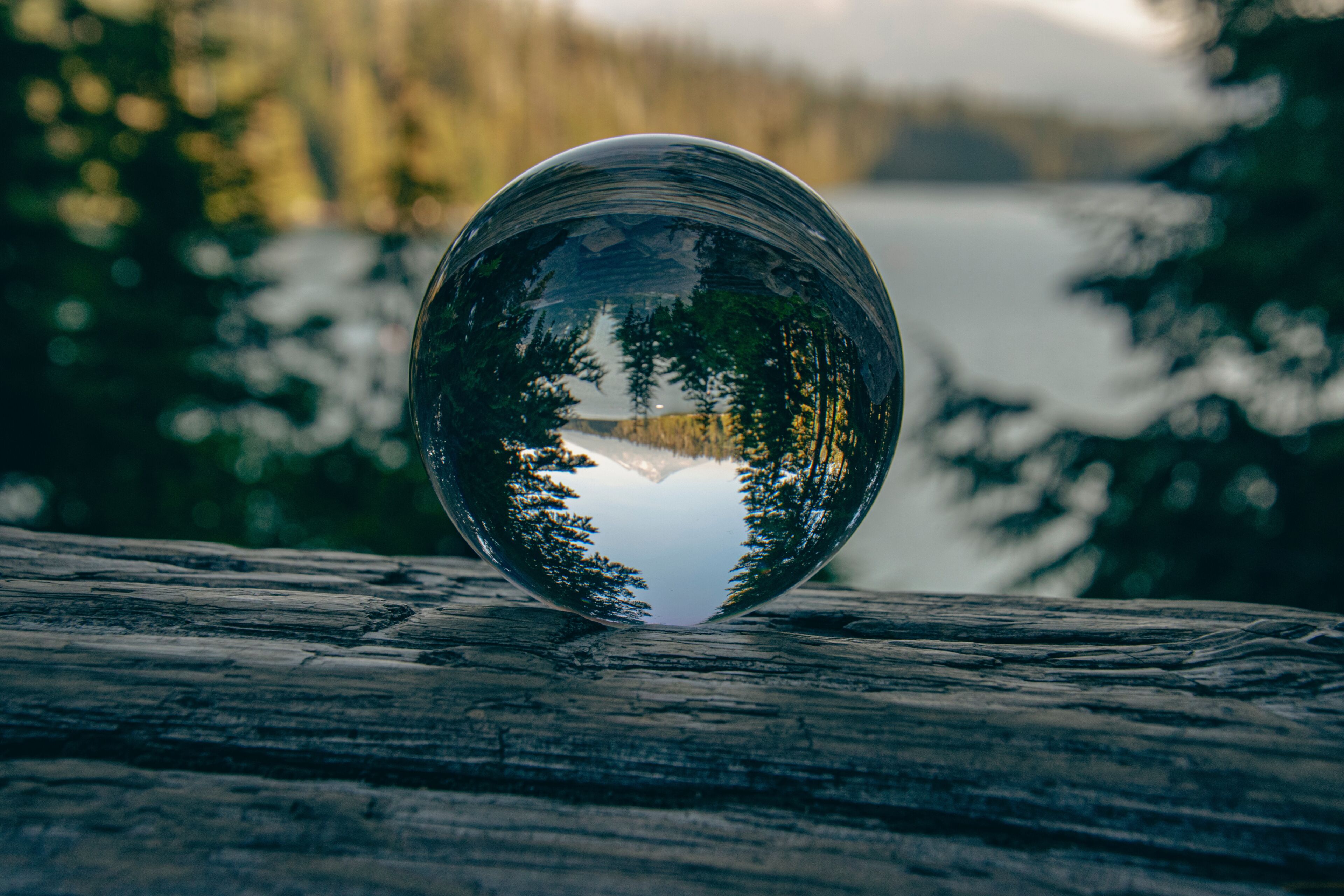 Reflection of Mount Hood, the Lost Lake, and pine trees in a crystal ball.  The image was taken on an autumn day in Oregon, USA.    