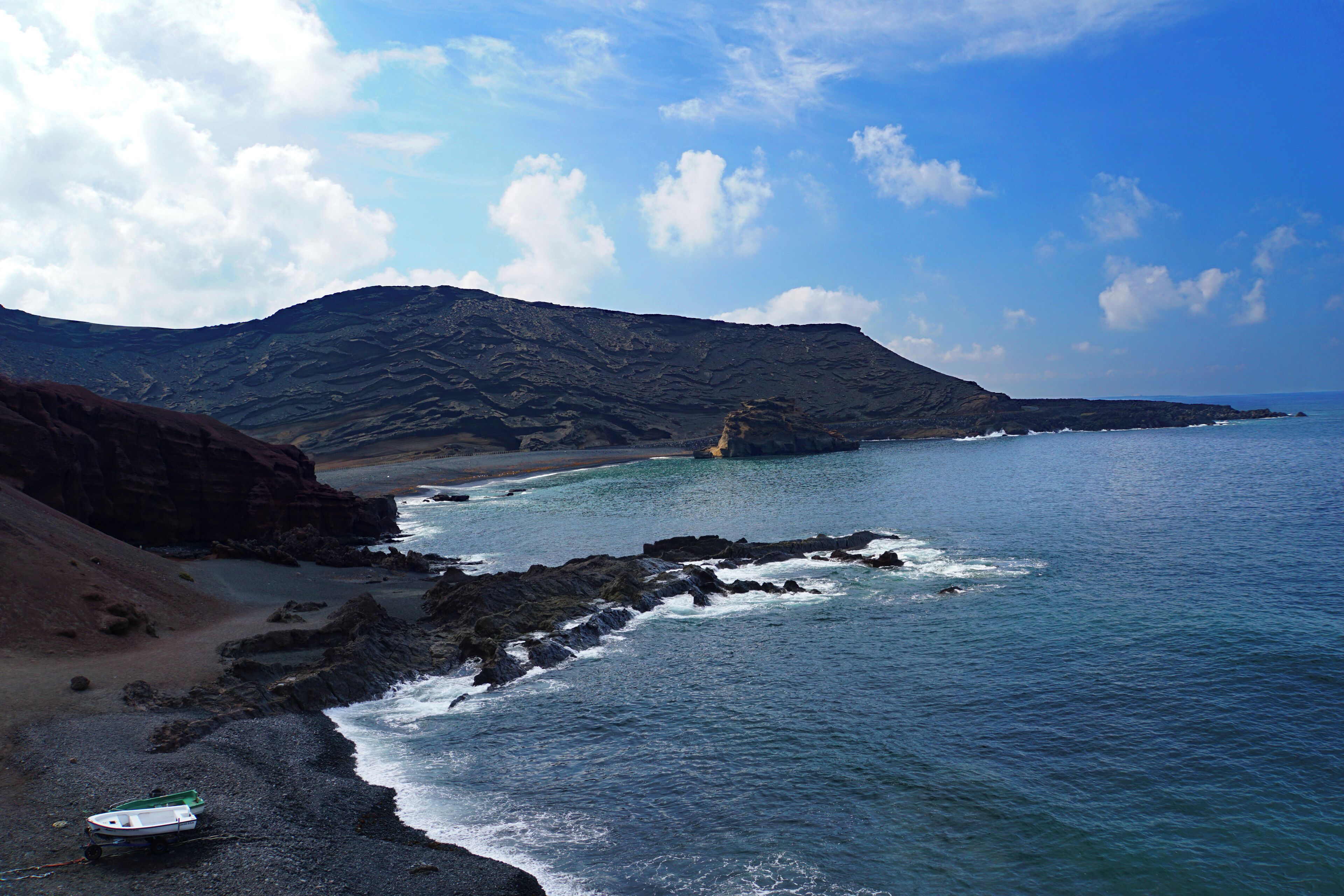 A surreal black sand beach with fishing boats on the west coast of Lanzarote – formed over centuries by the ocean from fragments of lava and other volcanic minerals - this volcanic world looks like it belongs to another planet #LifeAtExpedia #SeasideDiscoveries