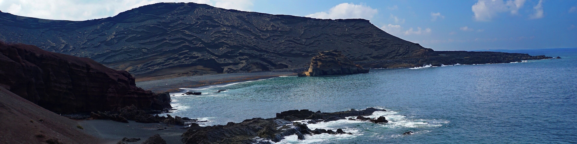 A surreal black sand beach with fishing boats on the west coast of Lanzarote – formed over centuries by the ocean from fragments of lava and other volcanic minerals - this volcanic world looks like it belongs to another planet #LifeAtExpedia #SeasideDiscoveries