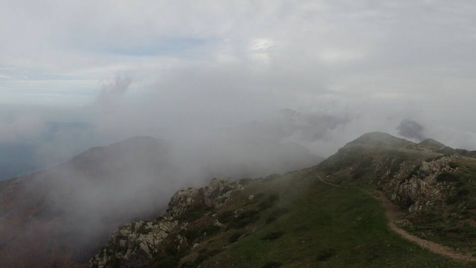 A mountainous landscape with a valley shrouded in mist.