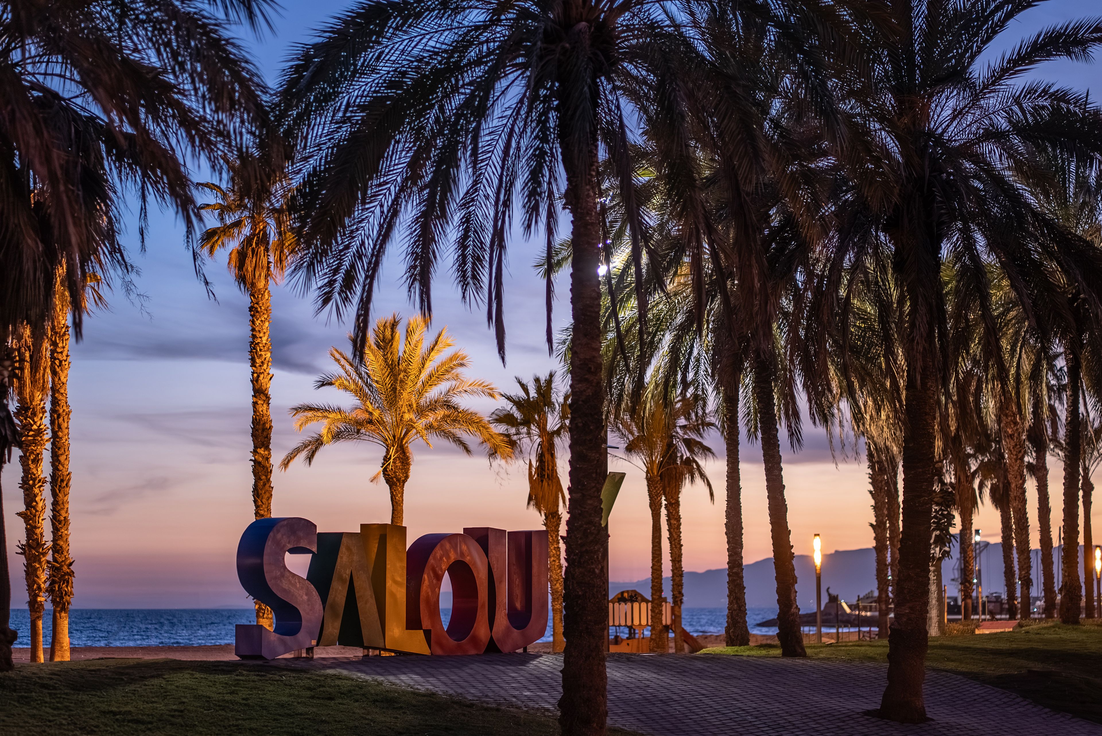 colorful letters of Salou town, palm trees andl beach at sunset, Catalonia, Spain