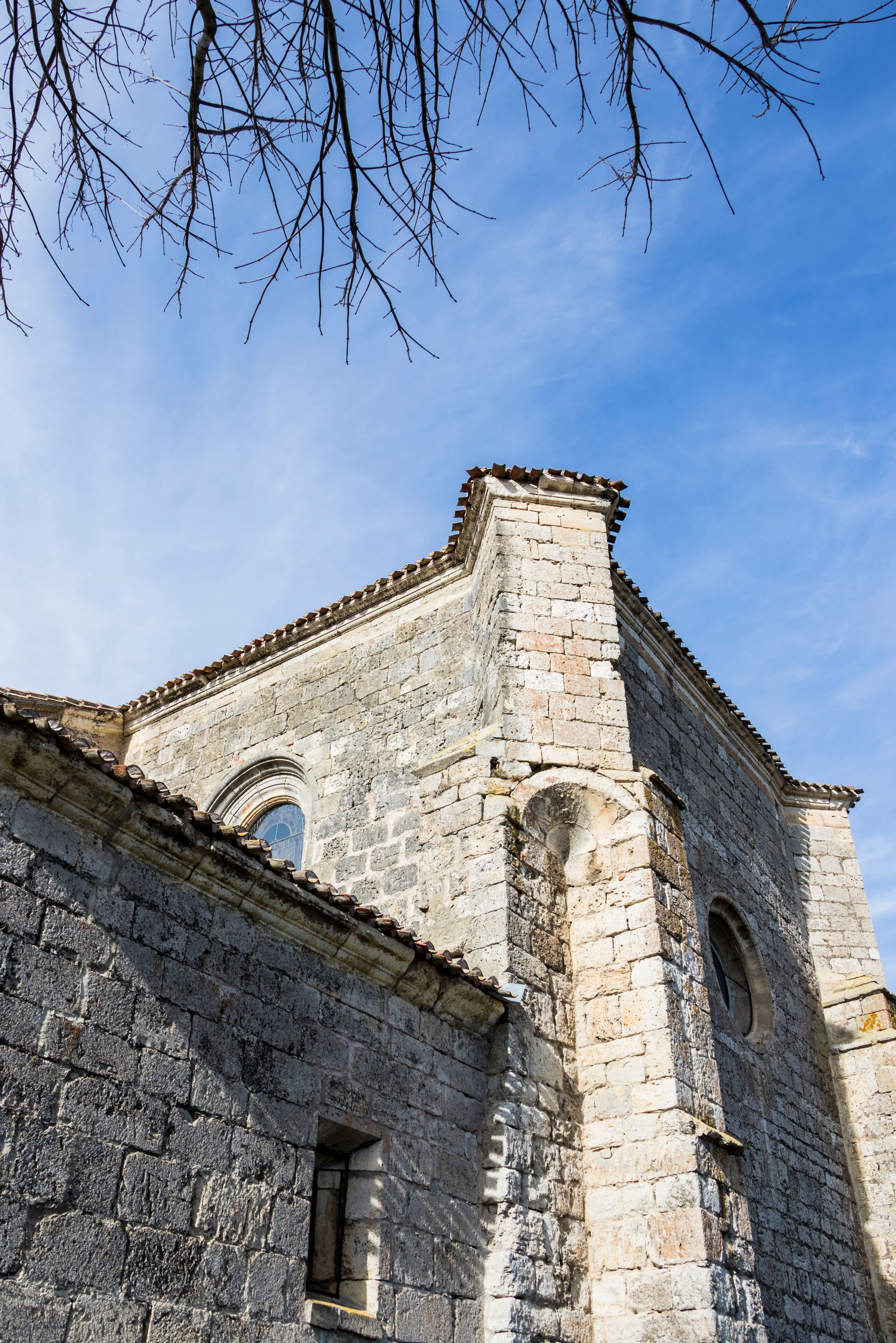 An old stone building with arched windows and a tiled roof.
