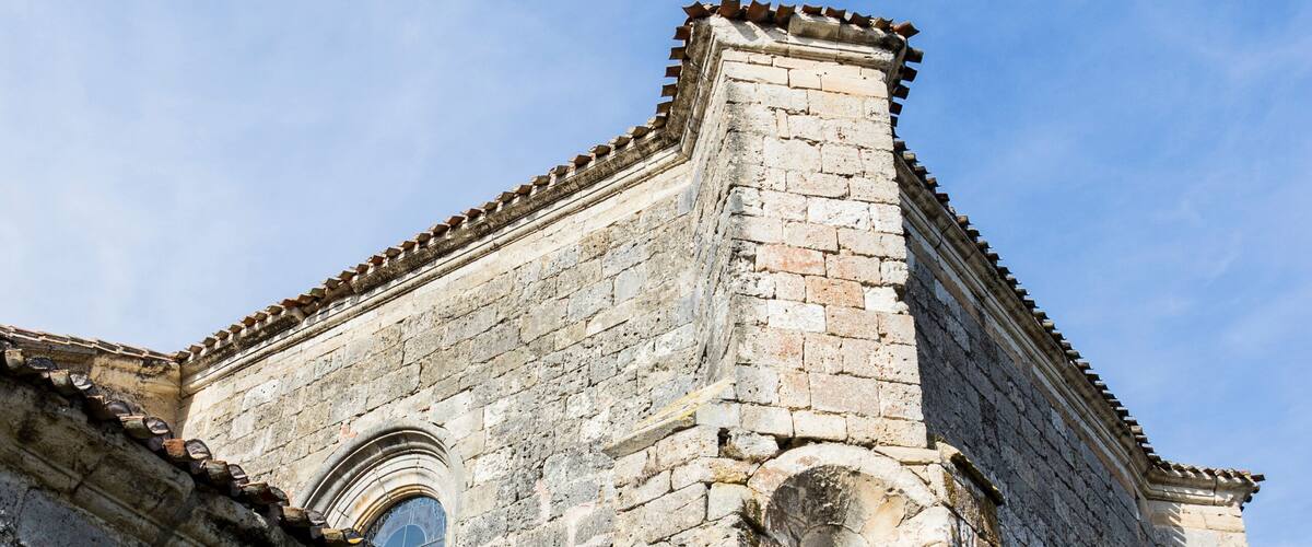 An old stone building with arched windows and a tiled roof.