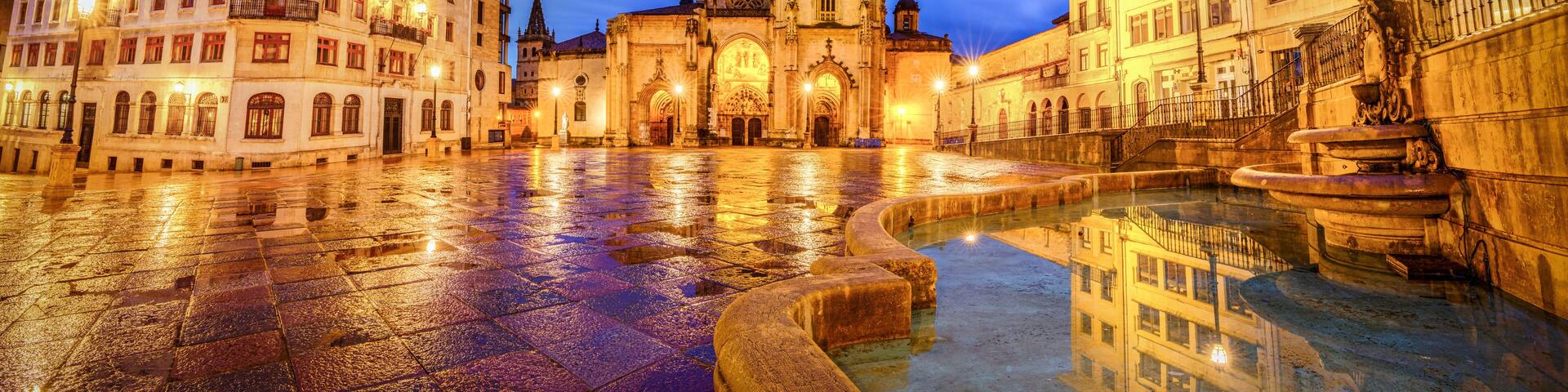 A historic square with a cathedral, a fountain, and surrounding buildings.
